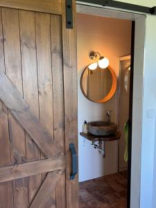 a bathroom with a wooden door and a sink at Ubytování u Kotrbů in Suchdol nad Lužnicí