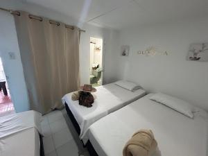 two beds in a room with a hat on it at Guajira Sunset Hostal in Ríohacha