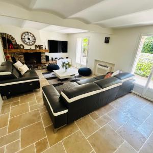 a living room with a black couch and a fireplace at Villa Sunlight Mougins in Mougins