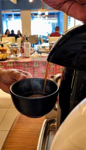 a person is holding a bowl filled with food at Pousada Recanto Paradise in Porto De Galinhas