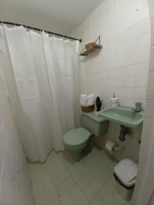 a bathroom with a green toilet and a sink at Guajira Sunset Hostal in Ríohacha