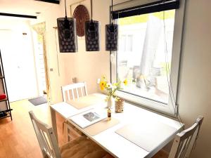 a dining room with a white table and a window at Knus houten huisje bij het bos in Anloo