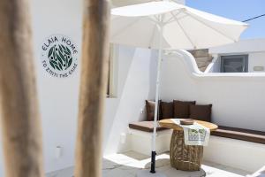 a table with an umbrella on a balcony at Elaia Home luxury village apartment for two Naxos in Galini