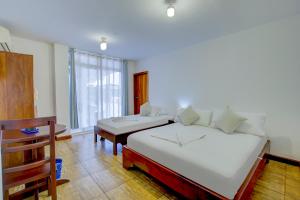a bedroom with a bed and a table and a window at Hotel Red Booby in Puerto Ayora