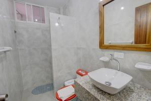 a bathroom with a white sink and a shower at Hotel Red Booby in Puerto Ayora