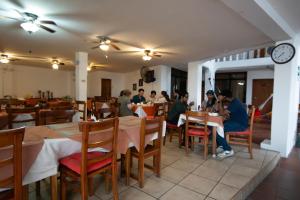 a group of people sitting at tables in a restaurant at Hotel Red Booby in Puerto Ayora