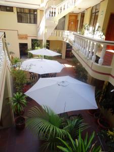 a courtyard with white umbrellas in a building at Hotel Red Booby in Puerto Ayora