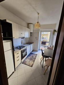 a kitchen with white appliances and a table and chairs at Appartamento spazioso ad Aosta in Aosta