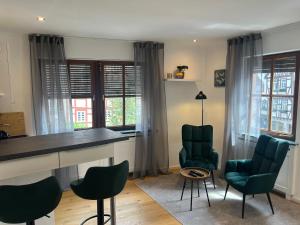 a kitchen with green chairs and a table and some windows at Modernes Altstadtappartment Suite Plötze 13 Limburg in Limburg an der Lahn +14 photos