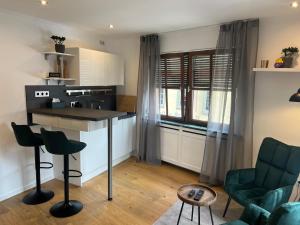 a kitchen with a counter and chairs in a room at Modernes Altstadtappartment Suite Plötze 13 Limburg in Limburg an der Lahn
