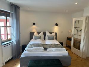 a bedroom with a bed with white sheets and pillows at Modernes Altstadtappartment Suite Plötze 13 Limburg in Limburg an der Lahn