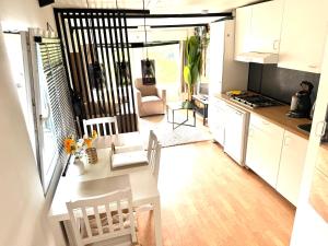 a kitchen and living room with a table and chairs at Knus houten huisje bij het bos in Anloo