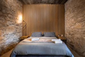 a bedroom with a large bed in a stone wall at Philoxenia Stone Suites in Choulou