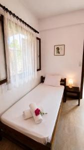 a bedroom with a large white bed with flowers on it at Revival rooms in Nikiana