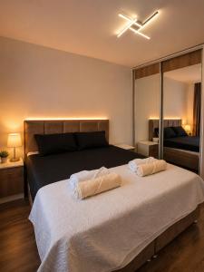 a bedroom with a bed with two towels on it at Apartman Centar Paracin in Paraćin