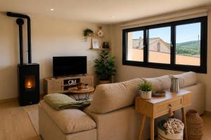 a living room with a couch and a flat screen tv at Casa Muxía Mar y montaña in Muxia