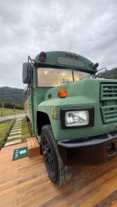a green truck parked on the side of a road at D'Alma Bus com café da manhã in Pomerode