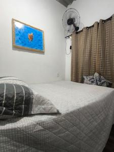a bedroom with a bed and a fan at Aconchego das Conchas in Mangaratiba