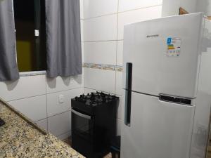 a white refrigerator in a kitchen with a stove at Aconchego das Conchas in Mangaratiba