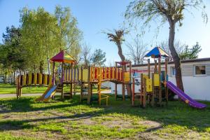 a playground with colorful equipment in a park at Przyczepa campingowa in Grzybowo