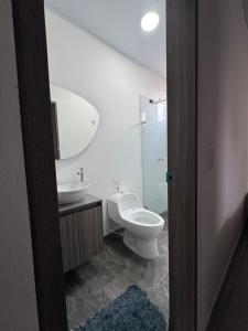 a bathroom with a toilet and a sink and a mirror at House premium in Macanal +5 photos