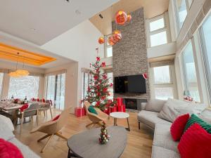 a living room with a christmas tree in it at Rose - Rusutsu Chalets in Kimobetsu