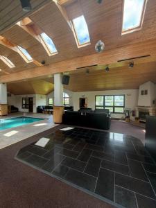 a large living room with a swimming pool and skylights at Hideout Villa in Hazlov