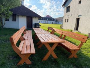 two wooden benches sitting in the grass next to a building at Hideout Villa in Hazlov