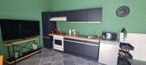 a small kitchen with a sink and a stove at Les Limousines - Proche de Pairi Daiza, Mons, Soignies in Soignies +2 photos