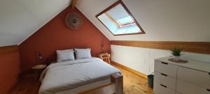 a attic bedroom with a bed and a window at Les Limousines - Proche de Pairi Daiza, Mons, Soignies in Soignies