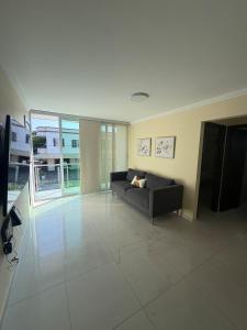 a living room with a couch on a tiled floor at Apartamento amoblado Murillo in Barranquilla