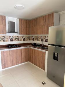 a kitchen with wooden cabinets and a stainless steel refrigerator at Apartamento amoblado Murillo in Barranquilla