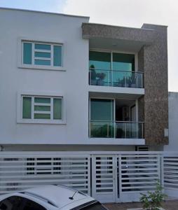 a white house with a car parked in front of it at Apartamento amoblado Murillo in Barranquilla