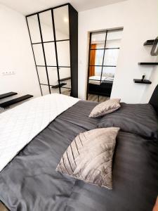 a bedroom with a large bed and two windows at Exclusive Apartament Centrum 45m in Tarnów