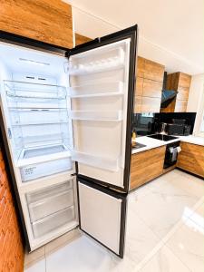 a refrigerator with its door open in a kitchen at Exclusive Apartament Centrum 45m in Tarnów