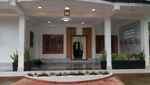 a front porch of a house with plants at Apex inn in Manippai