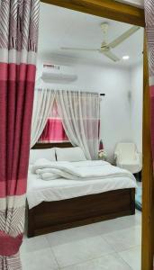 a bedroom with a bed and a window with curtains at Apex inn in Manippai