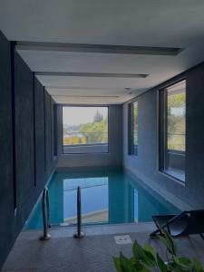 a swimming pool in a house with windows at Apartman Katica in Bečići