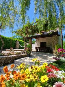 a garden with flowers and a fireplace at Kuća za odmor Buk in Čapljina