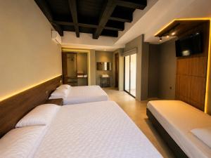 a room with four beds and a television in it at Hotel La Leonelda in Ocaña