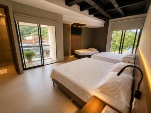a bedroom with two beds and a large window at Hotel La Leonelda in Ocaña