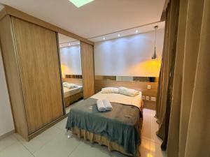 a bedroom with a bed and a large mirror at Apartamento 4 Quartos Completo UEMG Parque Expô in Divinópolis