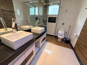 a bathroom with two sinks and a toilet at Apartamento 4 Quartos Completo UEMG Parque Expô in Divinópolis