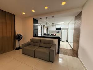 a living room with a couch and a kitchen at Apartamento 4 Quartos Completo UEMG Parque Expô in Divinópolis +26 photos