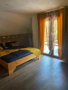 a bedroom with a bed and a large window at Plitvice Fairytale1 in Jezerce