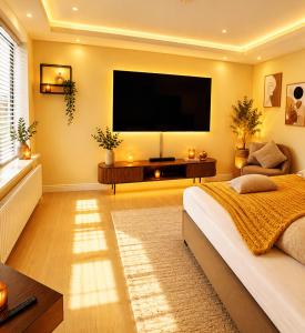 a bedroom with a large flat screen tv on the wall at 4SEASONS - Amber Spring Suite in Aalborg