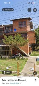 a brick house with a tree in front of it at Apto aconchegante no centro de Manaus in Manaus