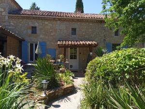 an old stone house with a garden in front of it at Gîte de La Planette in La Romieu