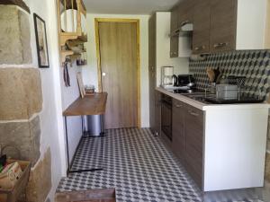 a kitchen with a counter and a floor in a room at Gîte de La Planette in La Romieu +6 photos