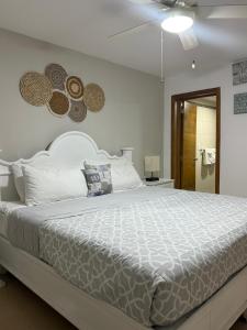 a bedroom with a large white bed with hats on the wall at Beach front Apt at Juan Dolio Marbella Apt Frente al mar 702 in San Pedro de Macorís +41 photos